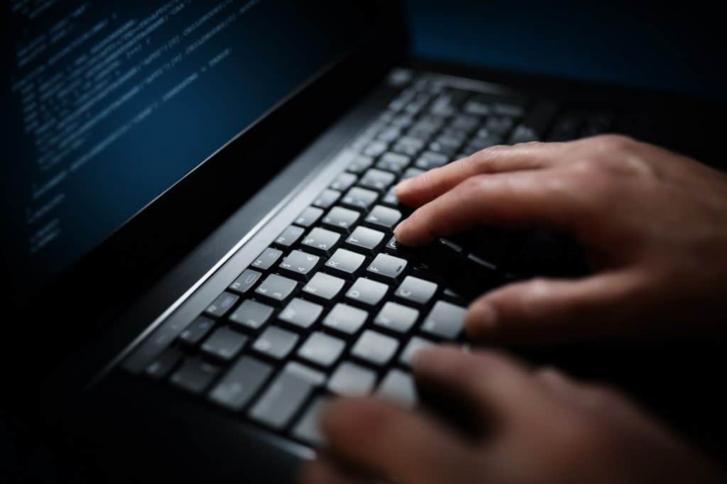 Programmer or computer hacker typing on laptop keyboard
