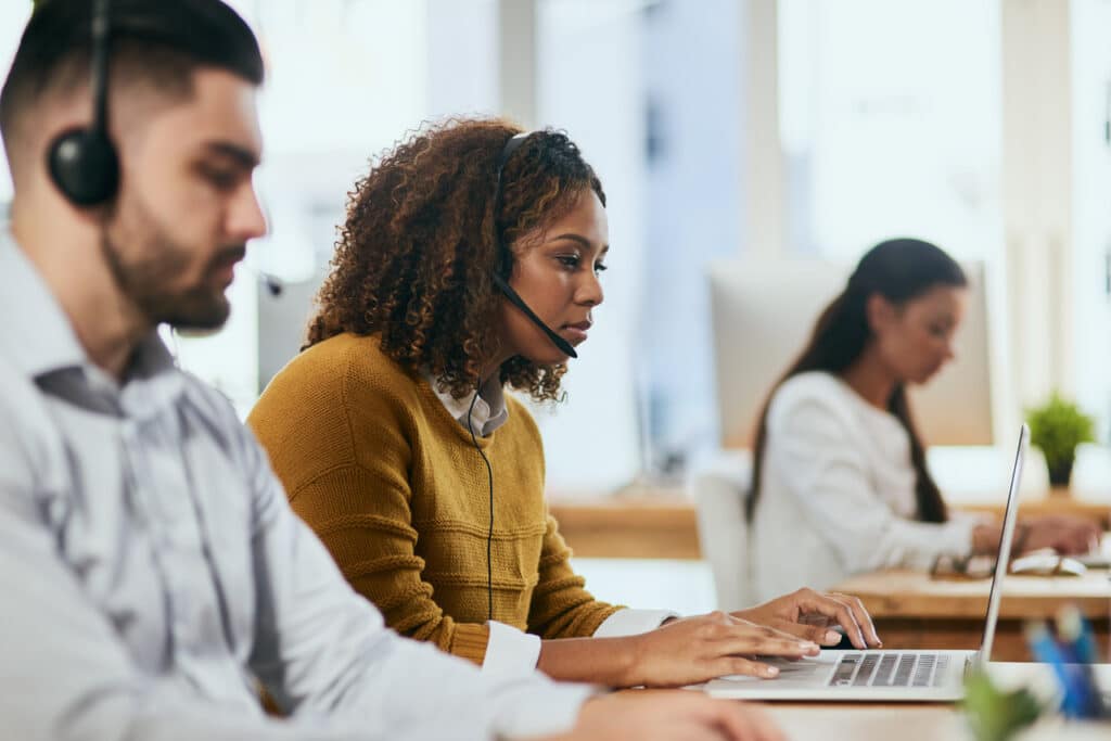 three proactive IT support people sitting at desks